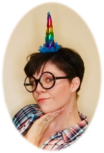 head of a woman wearing a rainbow unicorn horn and oversized fake glasses looking interestingly at the camera.